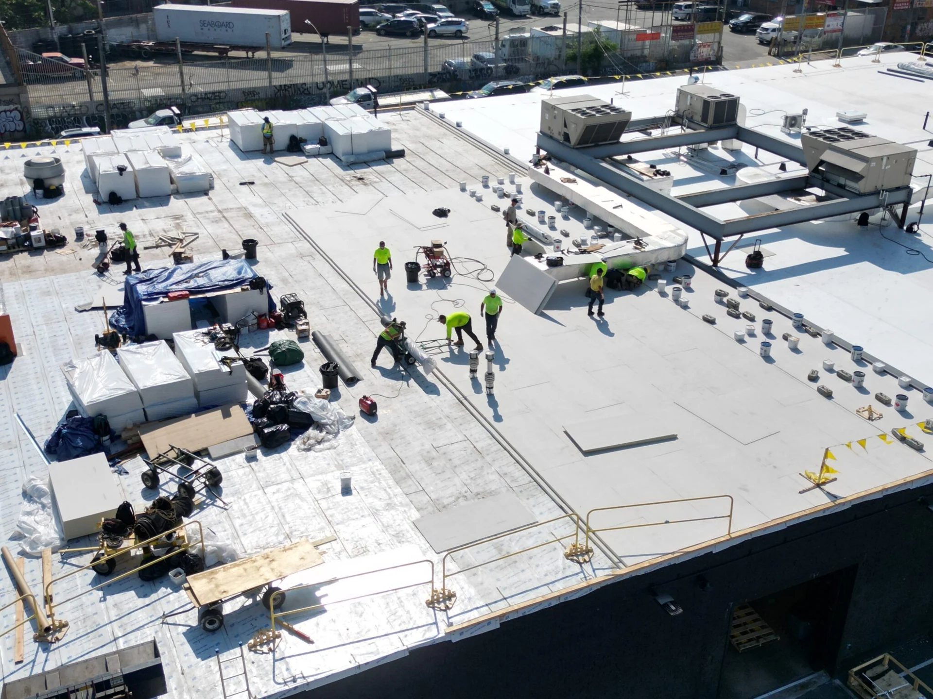 Roofing crew working across a commercial roof
